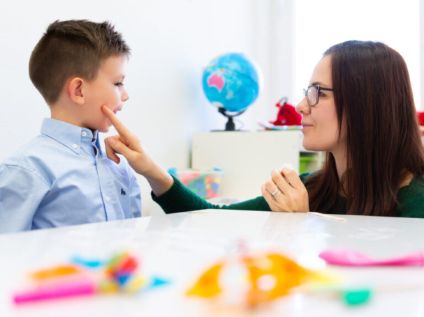 Children speech therapy concept. Preschooler practicing correct pronunciation with a female speech therapist.